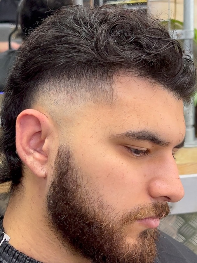 A skin fade with a shaped full beard.