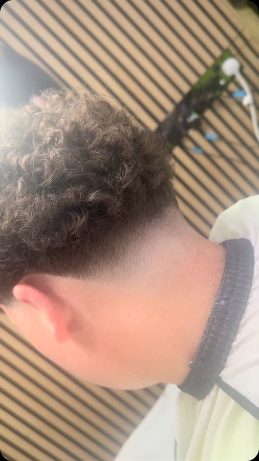 Tight curls over a skin fade.