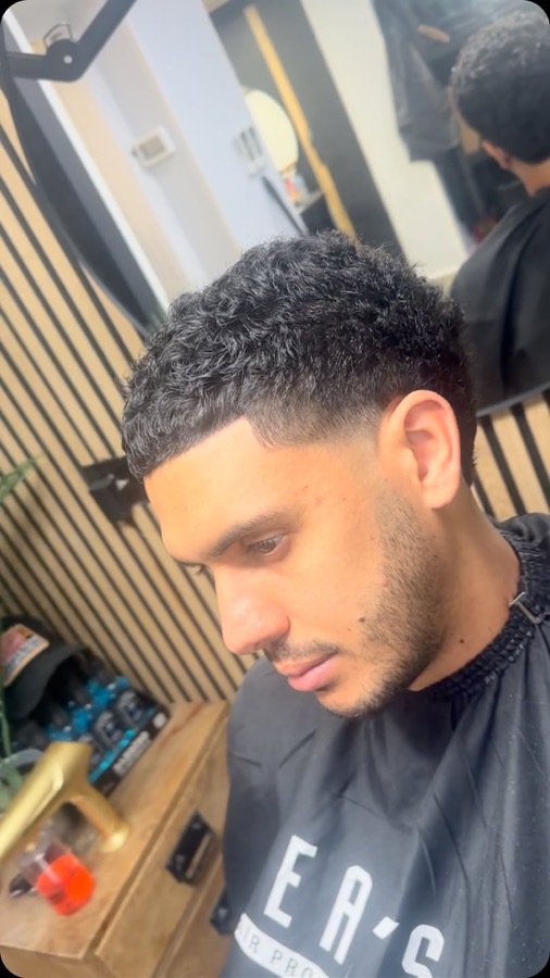A skin fade through tight curls.