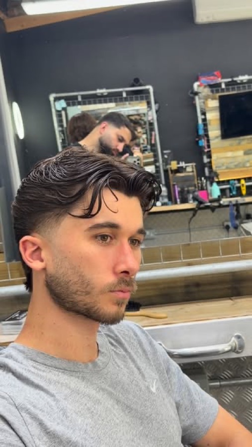 A dark textured quiff, front on.