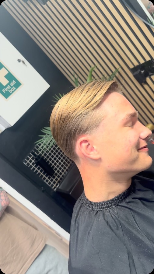 A blonde slick back with a faded side.