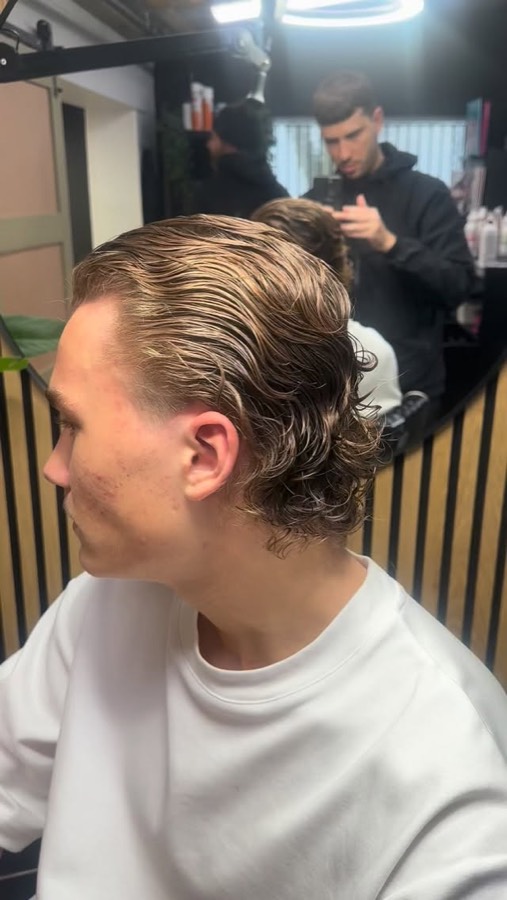 A blonde cut swept back off the face.